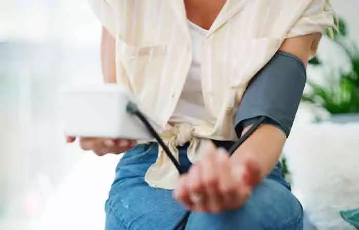 Woman measuring her blood pressure level at home