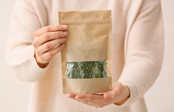 A woman chooses the best packet of green tea for skin benefits