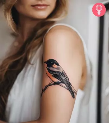 A woman with an owl tattoo on her upper arm