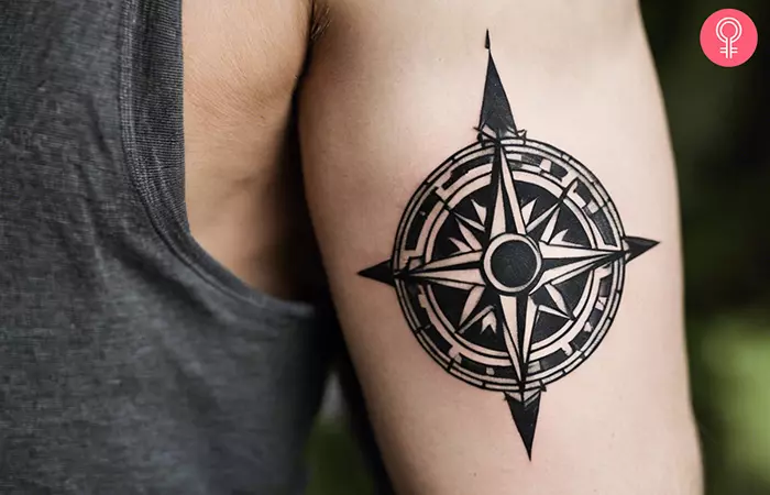 A man with a traditional black and white compass tattoo on his upper arm