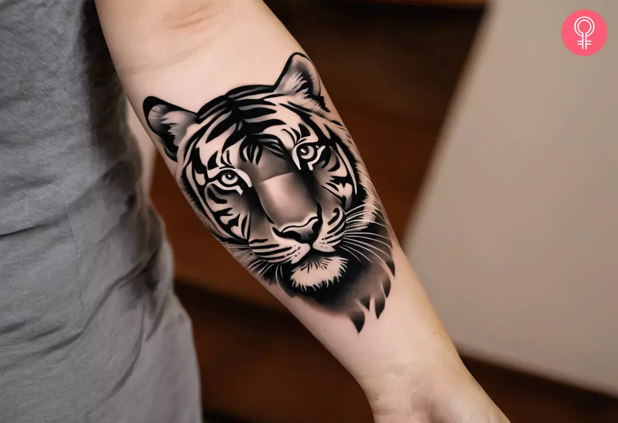 A tiger tattoo design on the forearm of a woman