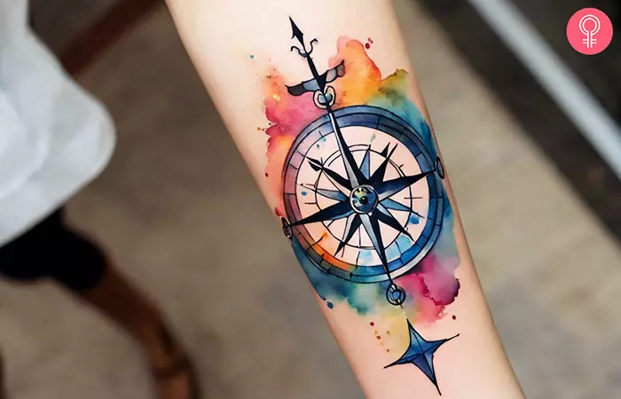 A woman with a watercolor compass tattoo on her forearm