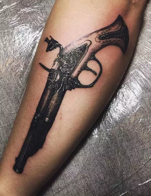 Monochrome antique gun tattoo design for forearm