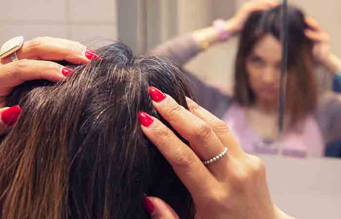 Woman checking her discolored hair in the mirror