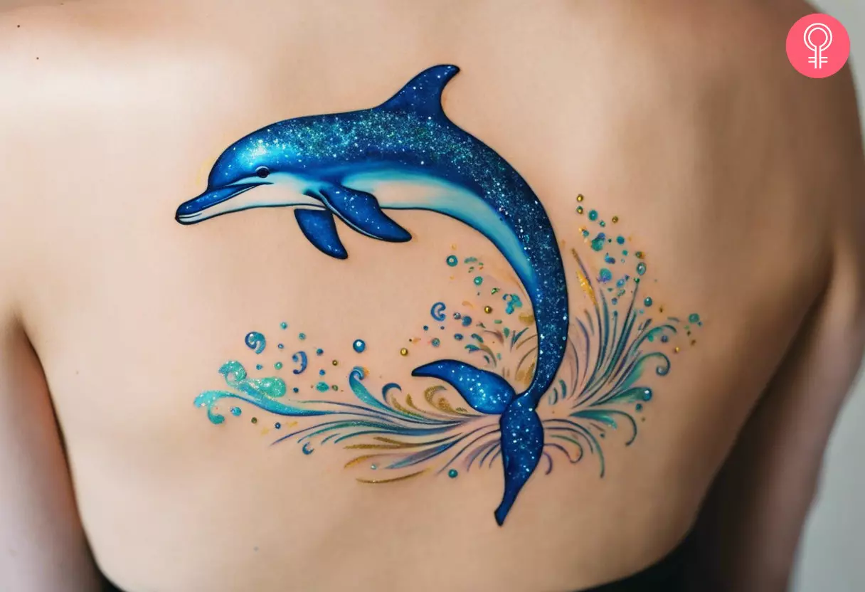 Happy dolphin glitter tattoo on the back of a woman