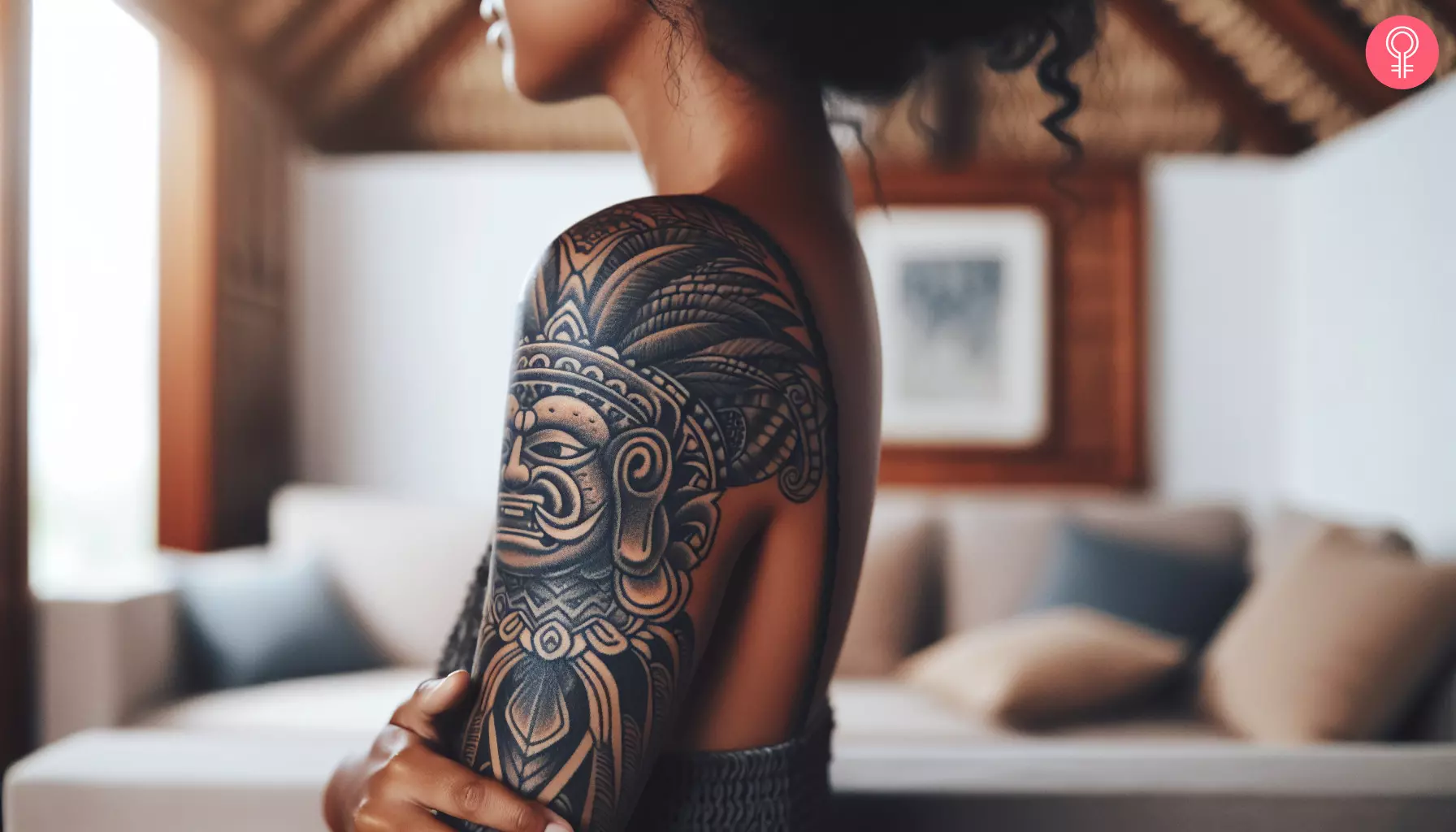 A Mayan god tattoo on a woman’s bicep