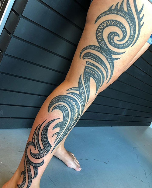 An intricate Polynesian leg tattoo