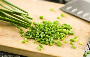 Chopped chives on wooden board