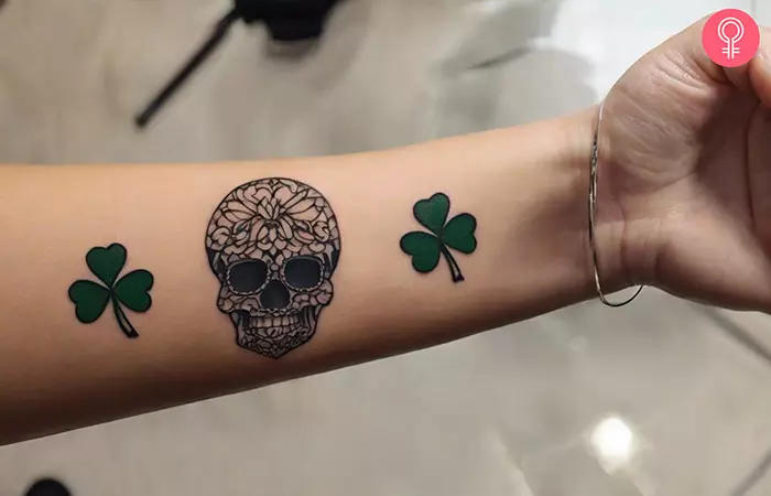 Woman-with-a-tattoo-of-shamrock-and-skull-on-her-forearm