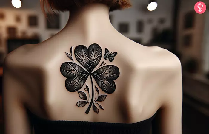 Woman with black shamrock tattoo on her upper back