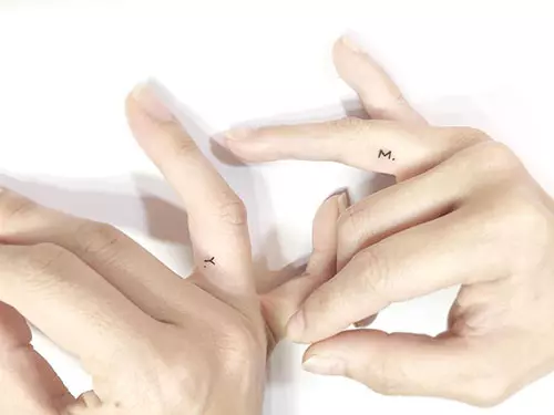 Initial tattoos on finger