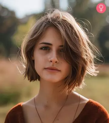 A woman with a red-colored fluffy pixie haircut