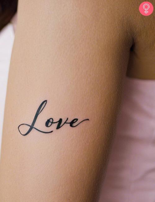 A tattoo of the word ‘Love’ on the arm of a woman