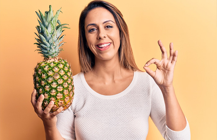 Woman indicating pineapples are good to eat.