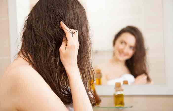 Молодая женщина наносит масло брингараджа для роста волос