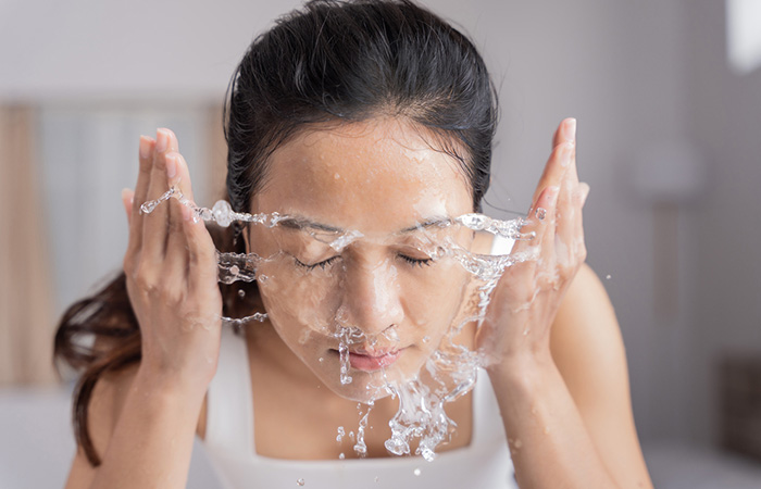 Woman washing her face to treat chin acne