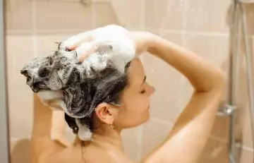 Woman using medicated shampoo to treat folliculitis hair loss
