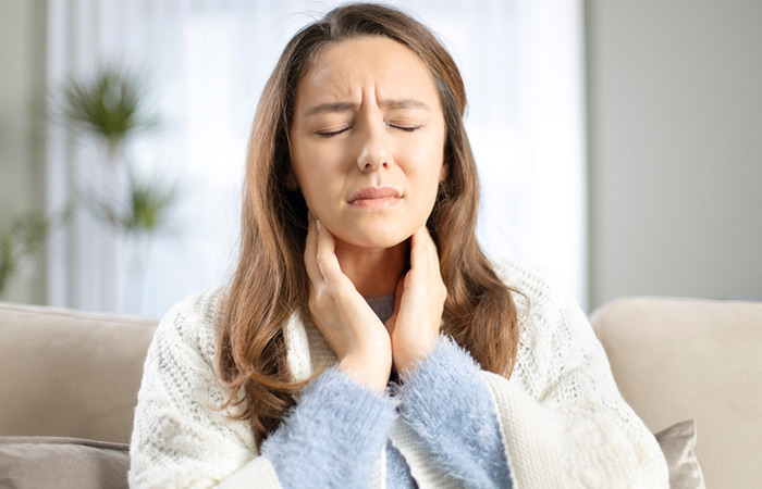 Woman experiencing sore throat