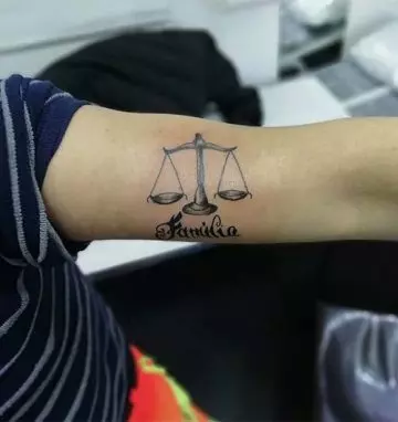 A personalized and authentic libra scale tattoo design for upper arm
