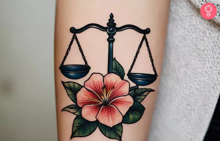A woman with a Libra birth flower tattoo on her forearm