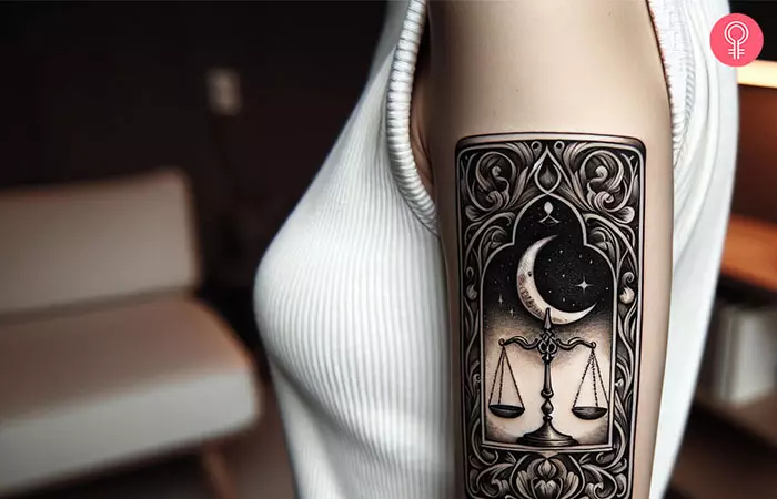 A woman with a Libra tarot card tattoo on her upper arm