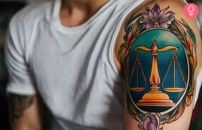 A male libra tattoo on the upper arm