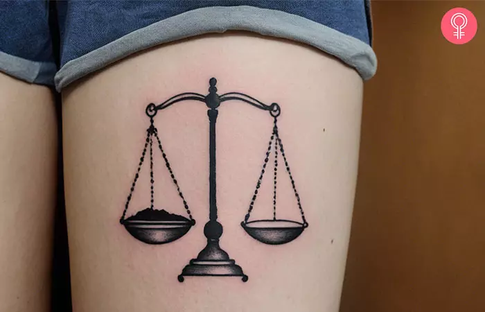 A woman with a Libra thigh tattoo