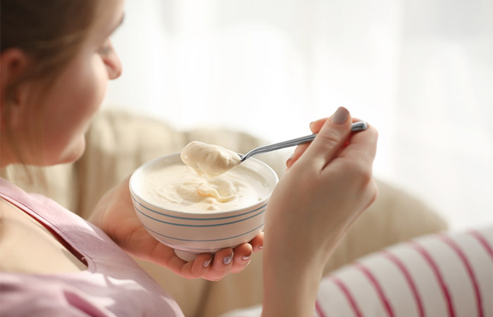 Close-up of a woman eating yogurt.