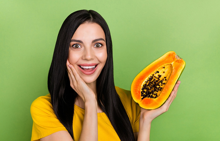Woman holding a halved papaya