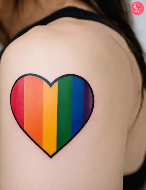 Simple LGBTQ heart tattoo on the upper arm of a woman