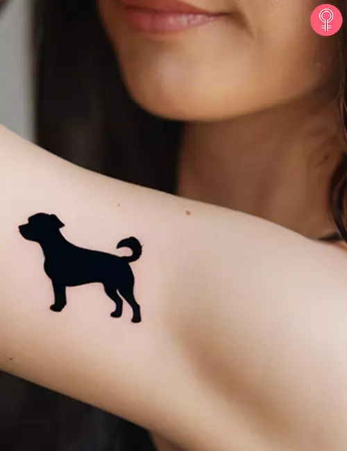 Simple dog tattoo on the shoulder of a woman