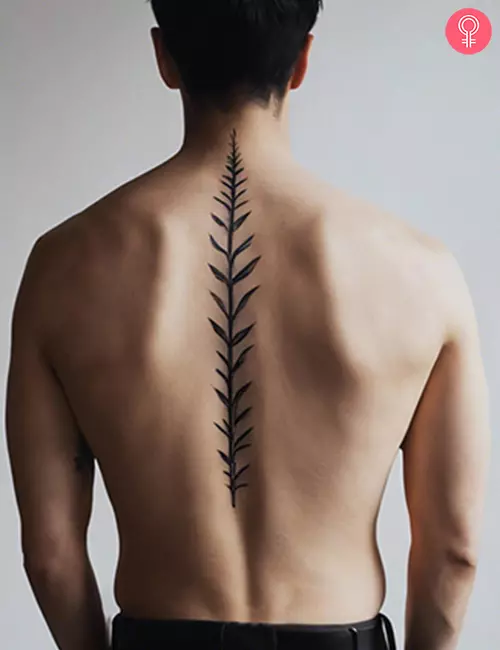 Simple leafy stem tattoo on the spine of a man