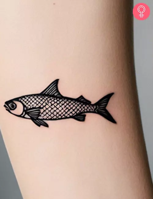 Simple small fish tattoo on the forearm of a woman