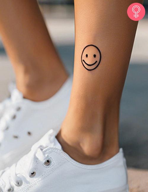 Simple smiley face tattoo on the leg of a woman