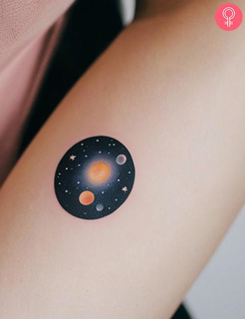 Simple space tattoo on the forearm of a woman