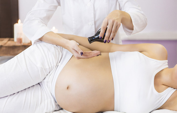 Pregnant woman having massage with sandalwood oil