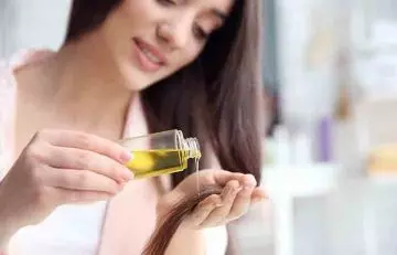Young woman applying coconut and bhringraj oil for hair growth