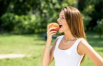 Woman eating an apple for liver health