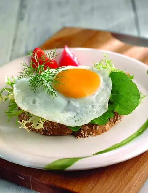 Fried egg and leftover salad open sandwich