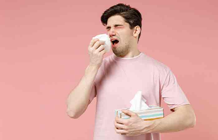 Man-holding-a-napkin-and-sneezing-from-allergy-trigger-symptoms-as-a-side-effect-of-acai-berries