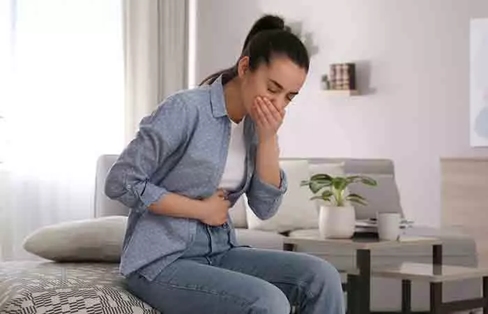 Young woman experiencing nausea at home