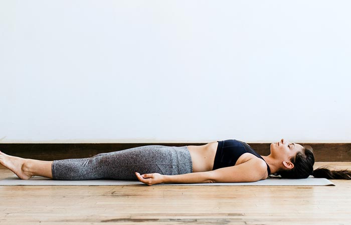 A woman cooling down her body with Shavasana at the end of the 108 sun salutation