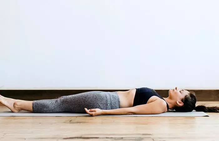 A woman cooling down her body with Shavasana at the end of the 108 sun salutation