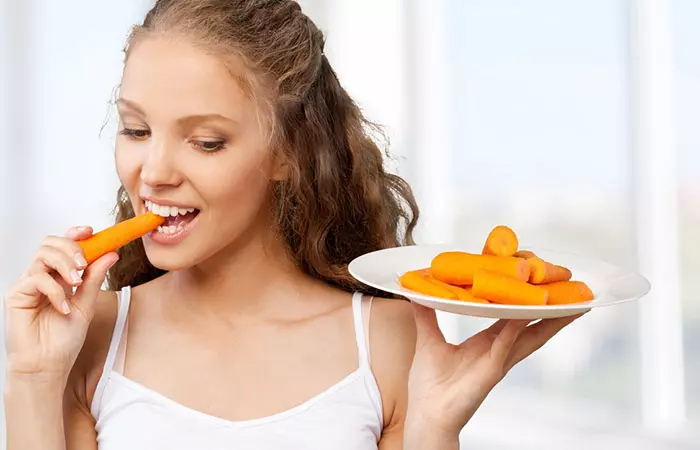 Woman eating carrots for vitamin A 
