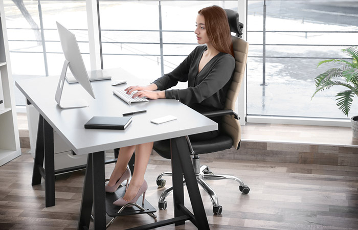 Woman sitting in the correct posture at office to avoid back pain. 