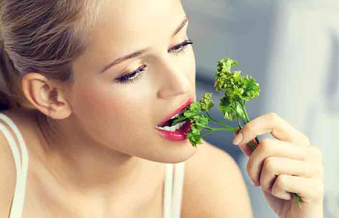 Young woman eating coriander to increase her appetite