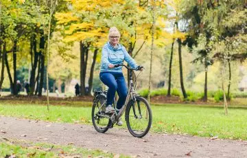 Woman cycling in the park to reduce uric acid