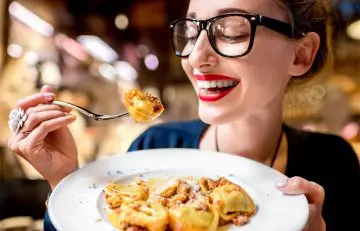Woman having pasta to reduce uric acid