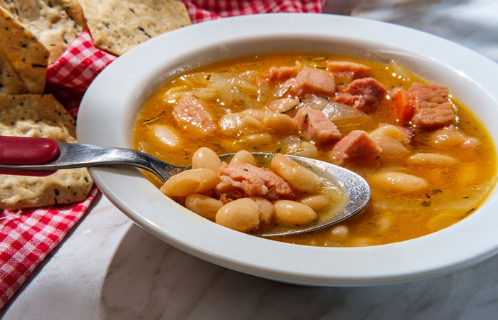 A bowl of navy bean soup with crackers