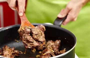 Woman cooking chicken liver